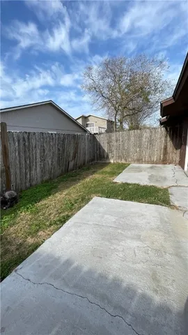 a view of backyard with wooden fence