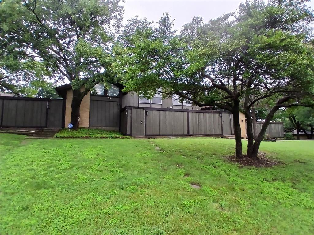 4640 Country Creek Drive, Unit 1257 Dallas, TX 75236 - Photo 11 of 11 a view of a backyard with large trees and wooden fence