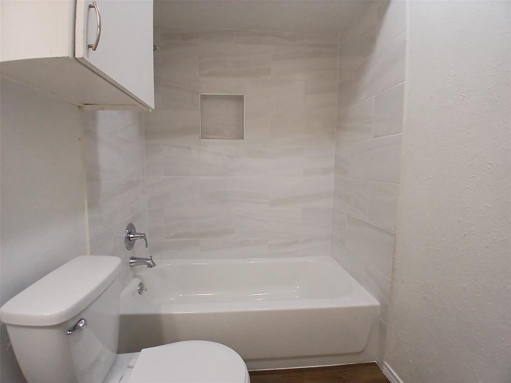 4640 Country Creek Drive, Unit 1257 Dallas, TX 75236 - Photo 10 of 11 a bathroom with a toilet and a bathtub