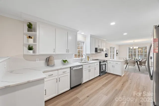 a kitchen with sink cabinets wooden floor and view living room
