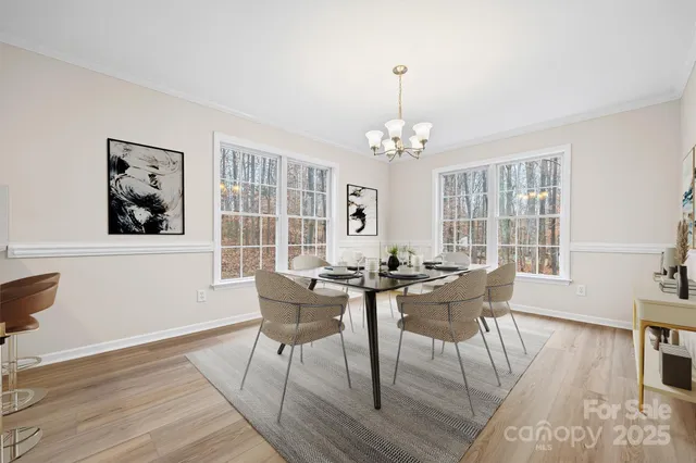 a view of a dining room with furniture a rug and wooden floor
