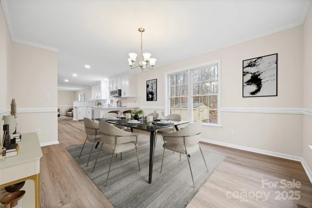 a view of a dining room with furniture wooden floor and a chandelier
