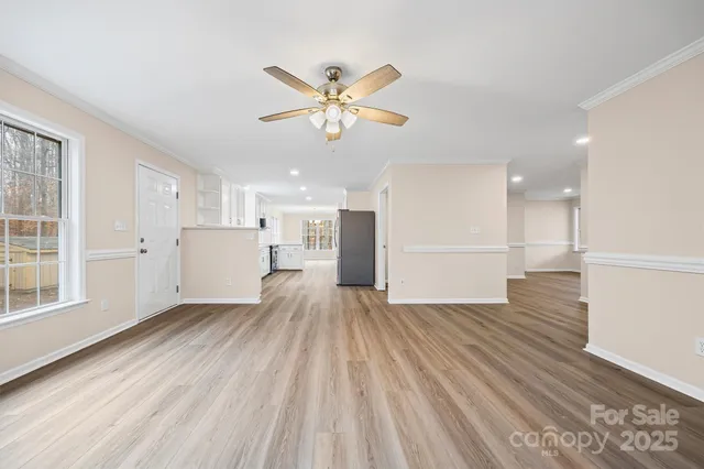 a view of a livingroom with wooden floor and a ceiling fan