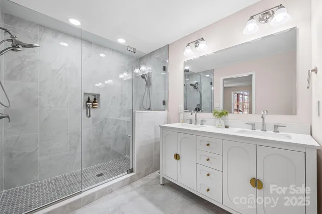 a bathroom with a double vanity sink mirror and shower