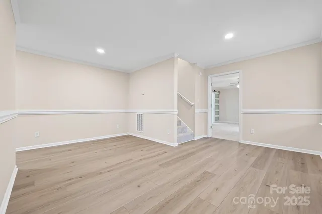 a view of an empty room with wooden floor
