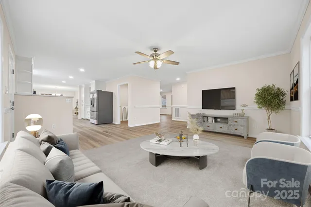 a living room with furniture kitchen view and a flat screen tv