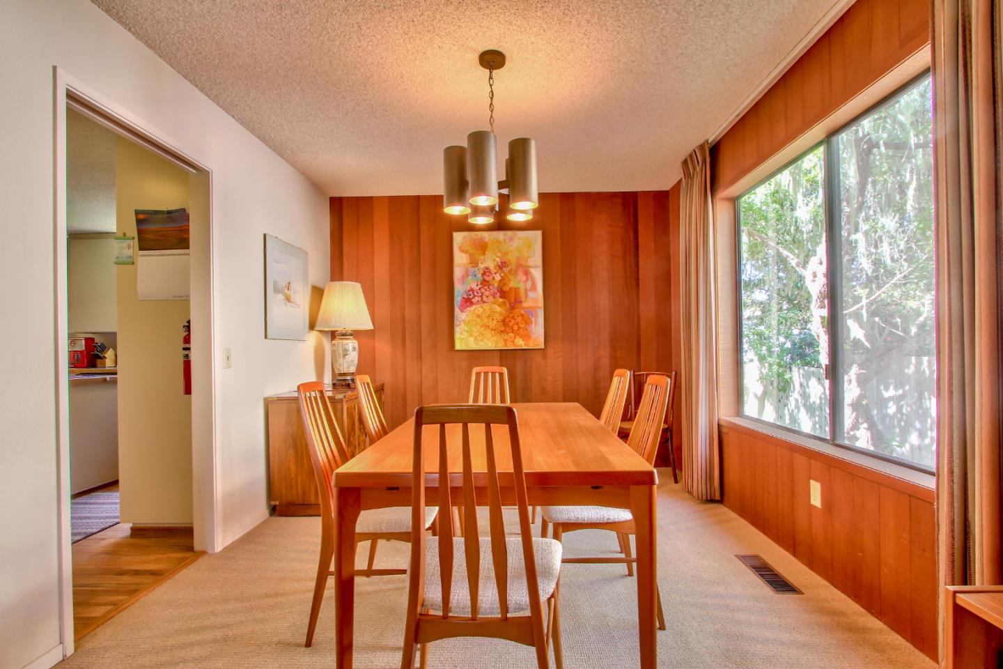 3036 Sloat Road Pebble Beach, CA 93953 - Photo 5 of 22 a dining room with wooden floor a chandelier a glass table and chairs