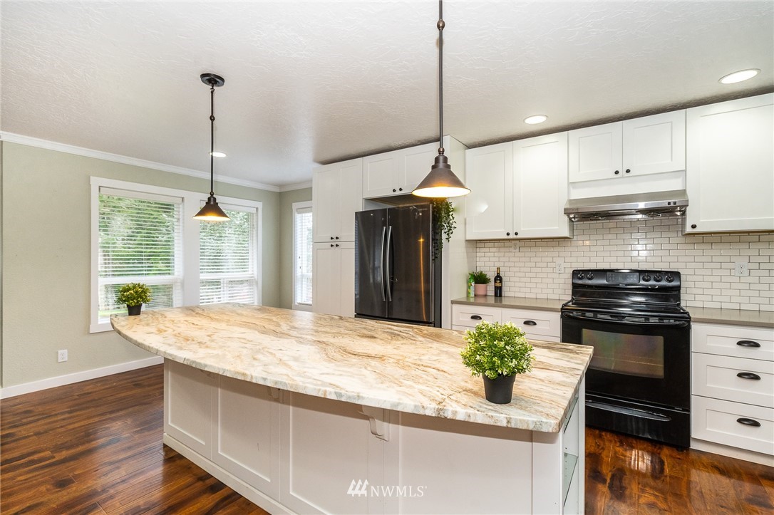 221 Berry Road Chehalis, WA 98532 - Photo 14 of 40 a kitchen with stainless steel appliances granite countertop a stove a sink and a wooden floors