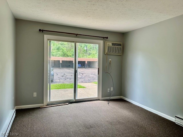 4376 Darrow Road, Unit 2 Stow, OH 44224 - Photo 2 of 26 Carpeted spare room with a baseboard radiator, an AC wall unit, baseboards, and a textured ceiling