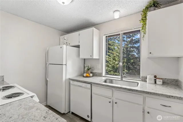 a kitchen with sink a refrigerator and window