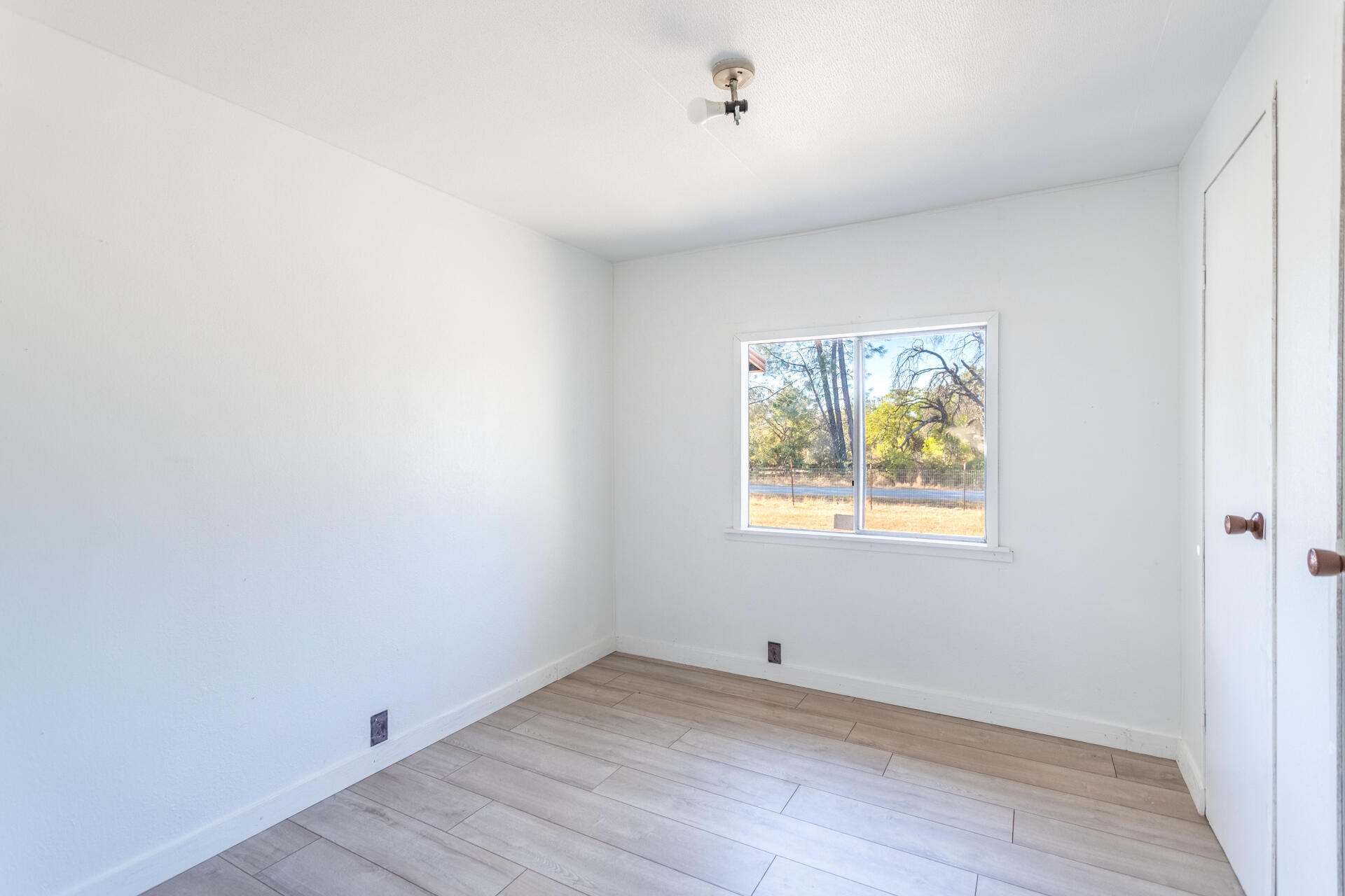 17594 Oly Way Anderson, CA 96007 - Photo 21 of 29 a view of an empty room with a window and wooden floor