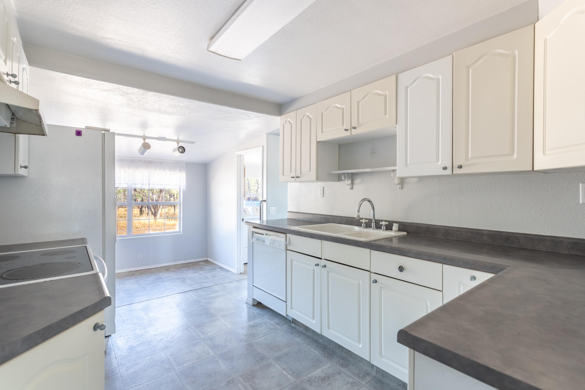 17594 Oly Way Anderson, CA 96007 - Photo 6 of 29 a kitchen with granite countertop a sink a stove and cabinets