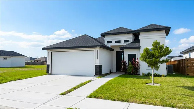a front view of a house with a yard and garage