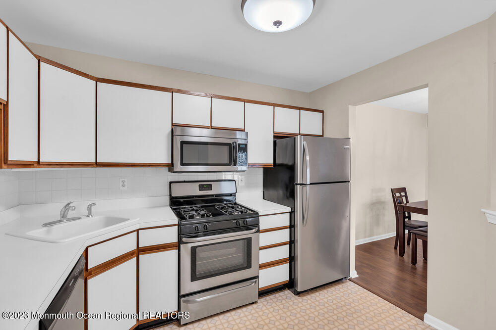 2206 Candlelight Court, Unit 2206 Helmetta, NJ 08828 - Photo 11 of 38 a kitchen with stainless steel appliances a refrigerator stove and sink