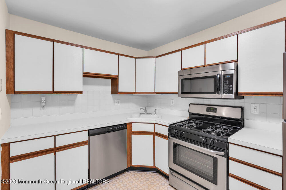 2206 Candlelight Court, Unit 2206 Helmetta, NJ 08828 - Photo 13 of 38 a kitchen with stainless steel appliances white cabinets and a stove top oven