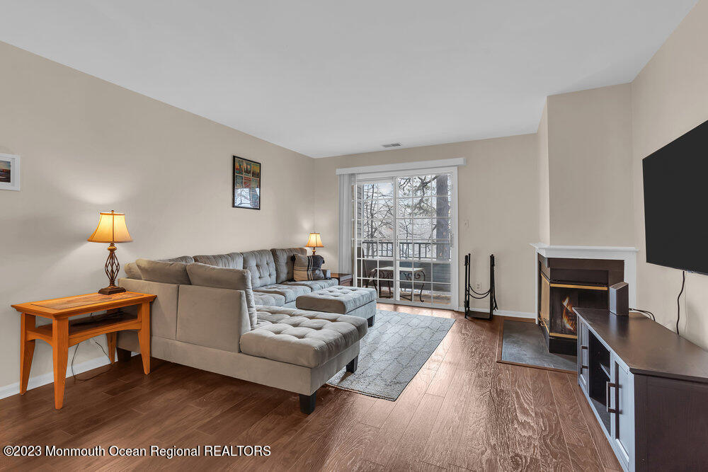 2206 Candlelight Court, Unit 2206 Helmetta, NJ 08828 - Photo 20 of 38 a living room with furniture a fireplace and a flat screen tv
