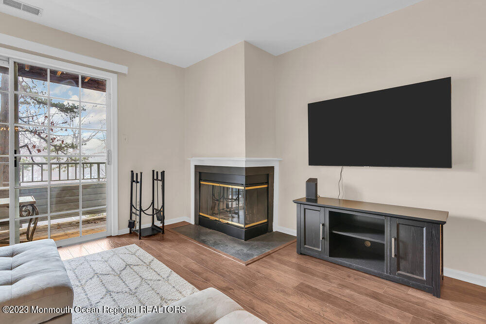 2206 Candlelight Court, Unit 2206 Helmetta, NJ 08828 - Photo 25 of 38 a living room with a flat screen tv a rug and a fireplace