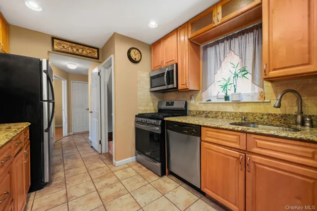 a kitchen with stainless steel appliances granite countertop a refrigerator and a stove top oven