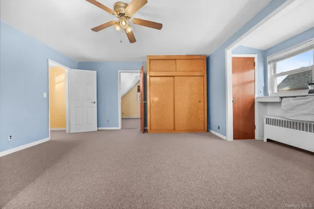 a view of empty room with window and ceiling fan