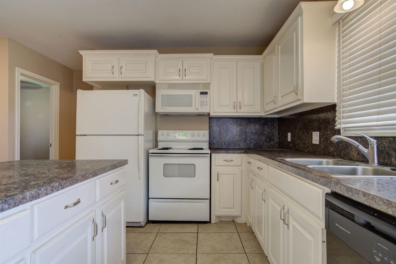 2601 33rd Street, Unit REAR Lubbock, TX 79410 - Photo 3 of 16 a kitchen with granite countertop cabinets stainless steel appliances and a sink