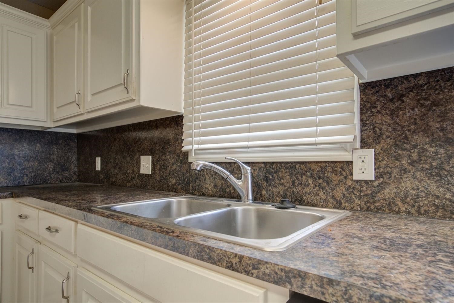 2601 33rd Street, Unit REAR Lubbock, TX 79410 - Photo 5 of 16 a kitchen with granite countertop a sink and a white wooden cabinets