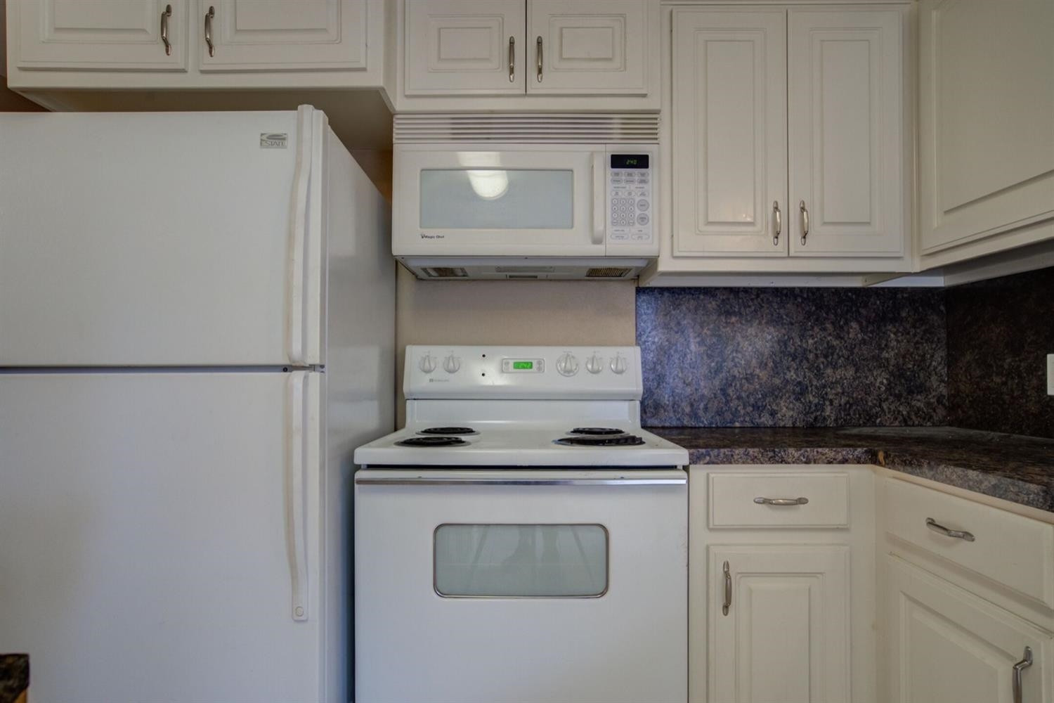 2601 33rd Street, Unit REAR Lubbock, TX 79410 - Photo 6 of 16 a kitchen with granite countertop white cabinets and white appliances