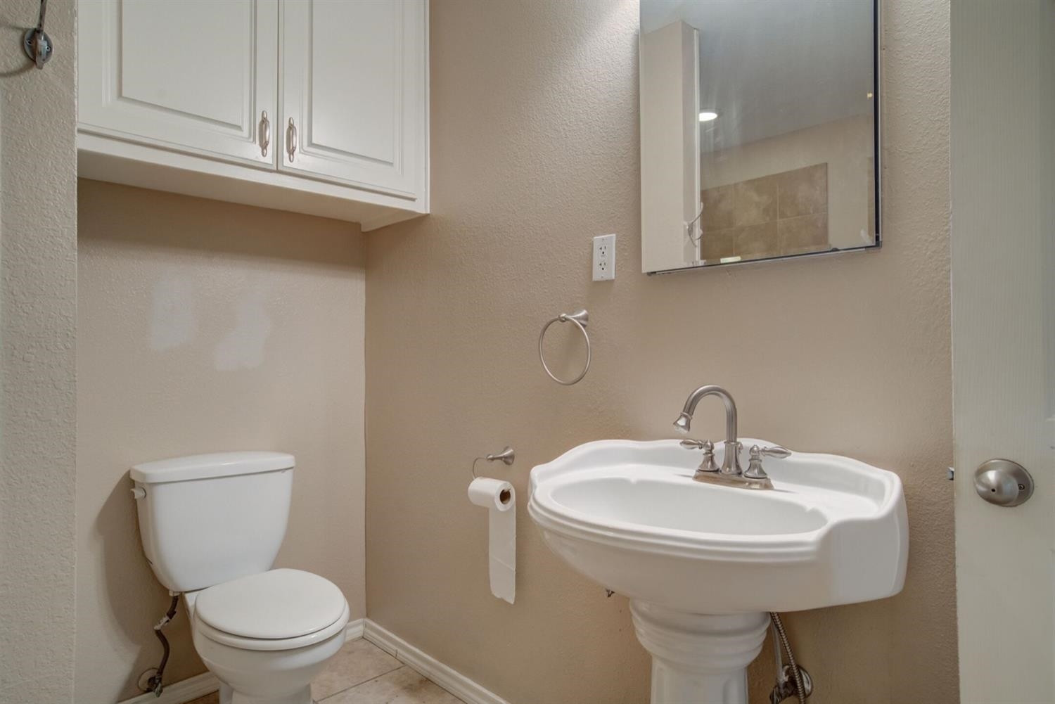 2601 33rd Street, Unit REAR Lubbock, TX 79410 - Photo 8 of 16 a bathroom with a toilet a sink and mirror