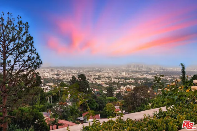 a view of empty room with wooden floor and large window