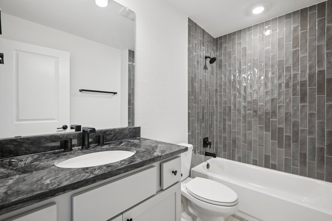 774 Jackson River Loop Kyle, TX 78640 - Photo 21 of 34 a bathroom with a granite countertop sink toilet and shower