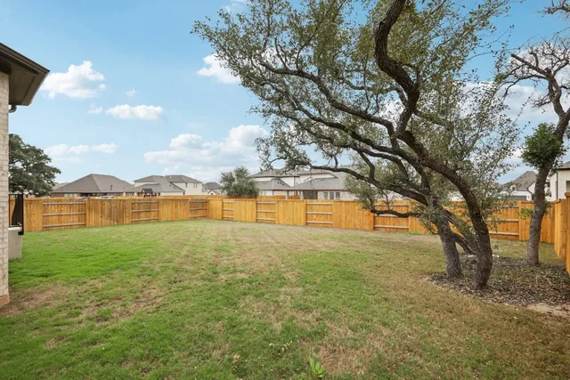 a view of yard with swimming pool and large trees