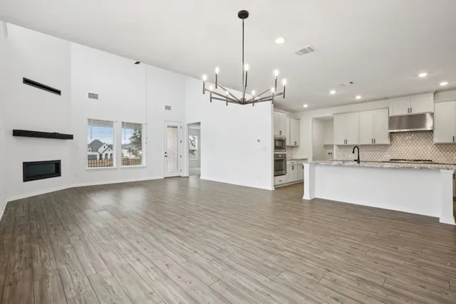 a view of an empty room and kitchen view