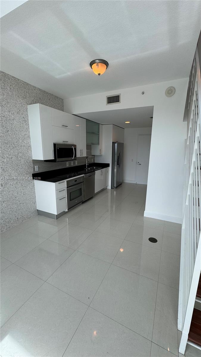 60 Southwest 13th Street, Unit 3015 Miami, FL 33130 - Photo 10 of 14 a kitchen with a stove and a microwave