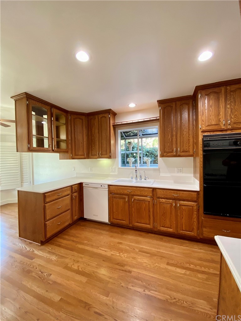 948 Cambridge Drive Burbank, CA 91504 - Photo 7 of 36 a large kitchen with stainless steel appliances granite countertop a stove a sink dishwasher and a refrigerator with wooden floor
