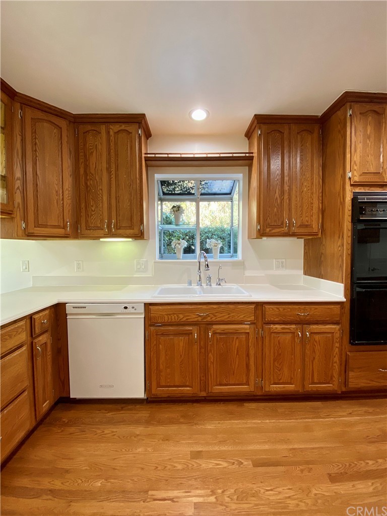 948 Cambridge Drive Burbank, CA 91504 - Photo 9 of 36 a large kitchen with stainless steel appliances granite countertop a sink and dishwasher a stove top oven with wooden floor