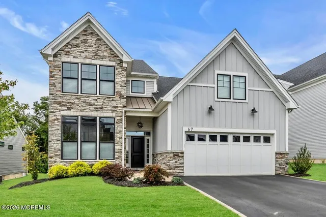 a view of a house with brick walls and a yard with plants