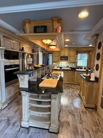 a kitchen with stainless steel appliances granite countertop a stove a sink and a microwave