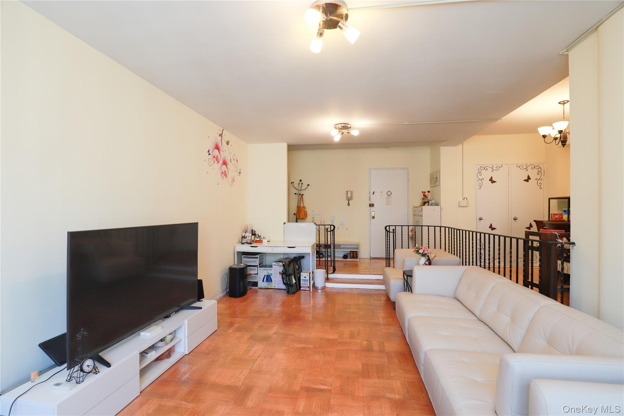 98-25 64th Road, Unit 6F Queens, NY 11374 - Photo 2 of 12 Open-concept living space featuring wood-finish flooring, recessed lighting, and a stepped entry
