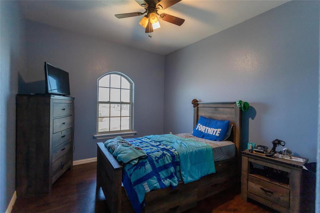 8900 Holly Road Alvarado, TX 76009 - Photo 11 of 17 Arched window, wood-finish flooring, and a ceiling fan with integrated lighting