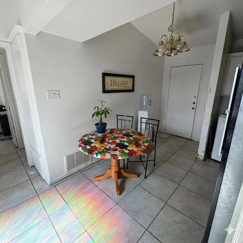 a bedroom with a bed a chair and the view kitchen