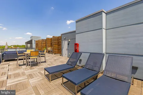 a roof deck with table and chairs