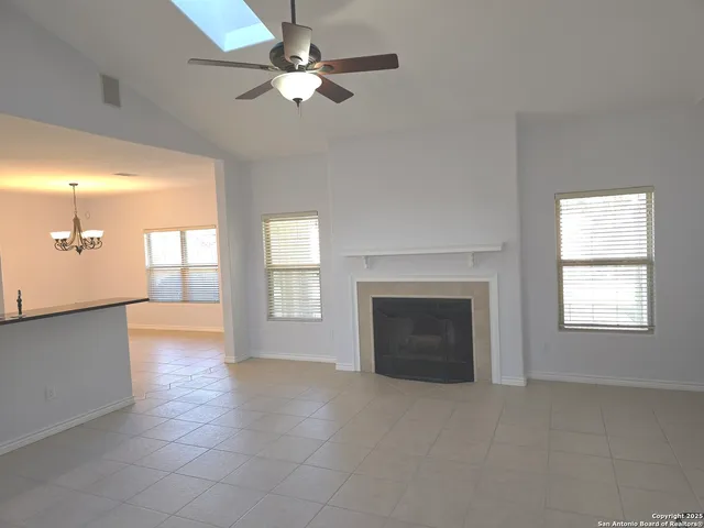 a view of an empty room with a fireplace and a window
