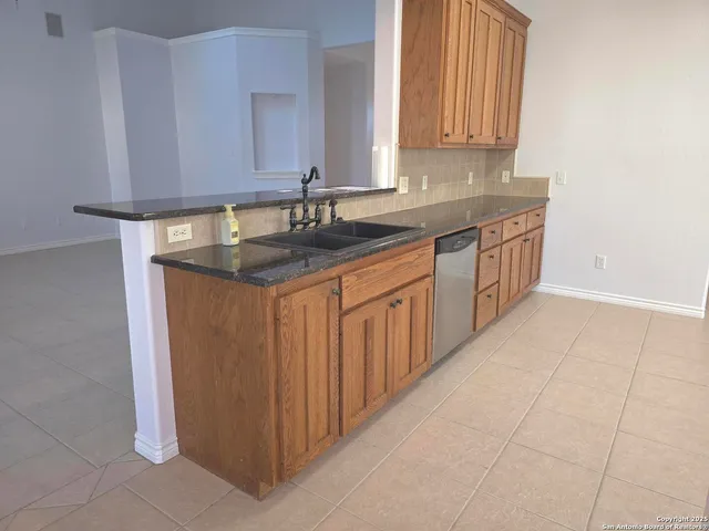 a kitchen with stainless steel appliances granite countertop a sink and a white cabinets