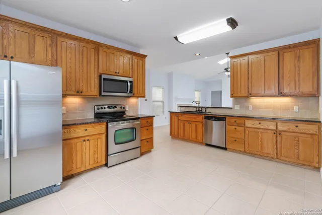 a kitchen with granite countertop stainless steel appliances and white cabinets