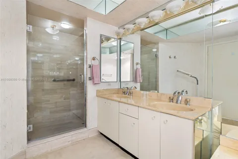 a bathroom with a double vanity sink mirror and shower