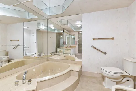 a bathroom with a sink a toilet and a large mirror
