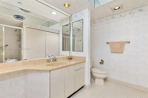 a bathroom with a double vanity sink toilet mirror and shower