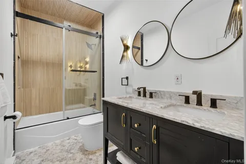 a bathroom with a granite countertop sink a mirror and a shower