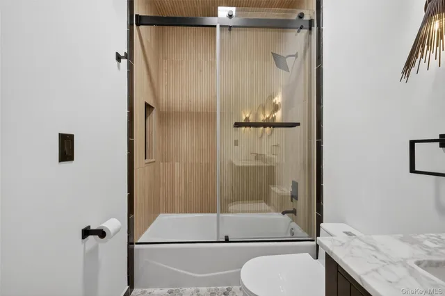 a bathroom with a granite countertop shower a toilet and a sink