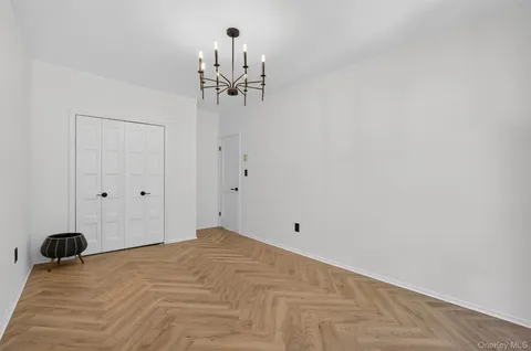 a view of a room with a hanging light and hardwood