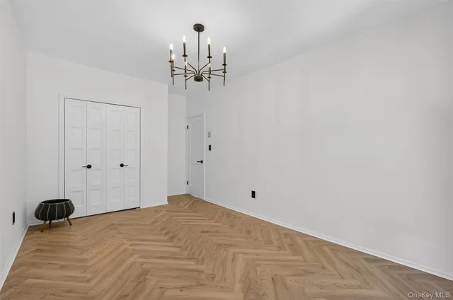 a view of a room with a hanging light and hardwood